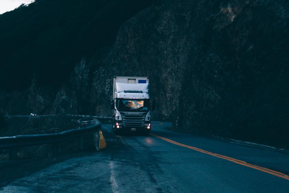 Caminhão em estrada de serra ao anoitecer